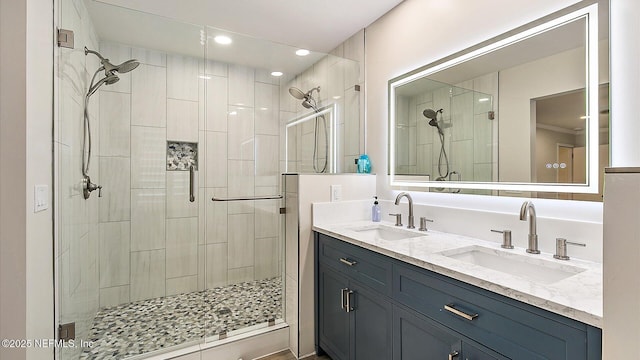 bathroom featuring a sink, a stall shower, and double vanity