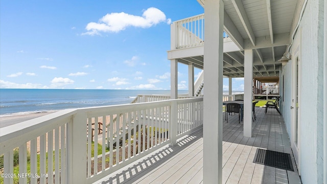 wooden deck with a view of the beach and a water view