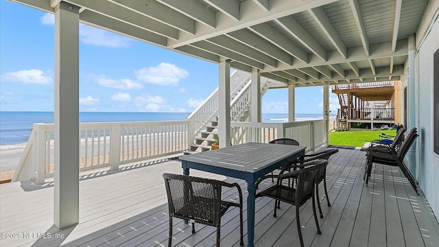 deck featuring a beach view and a water view