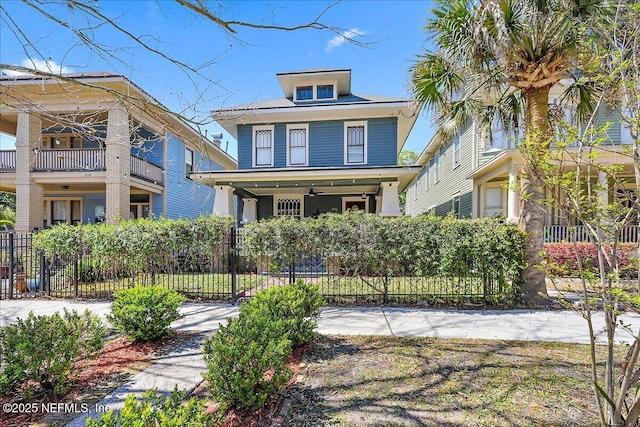 traditional style home with covered porch and a fenced front yard