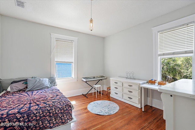 bedroom featuring visible vents, baseboards, and light wood-style flooring