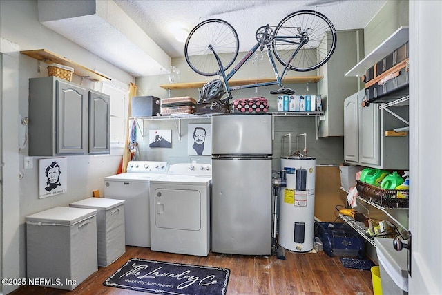 clothes washing area featuring laundry area, wood finished floors, water heater, and washing machine and clothes dryer