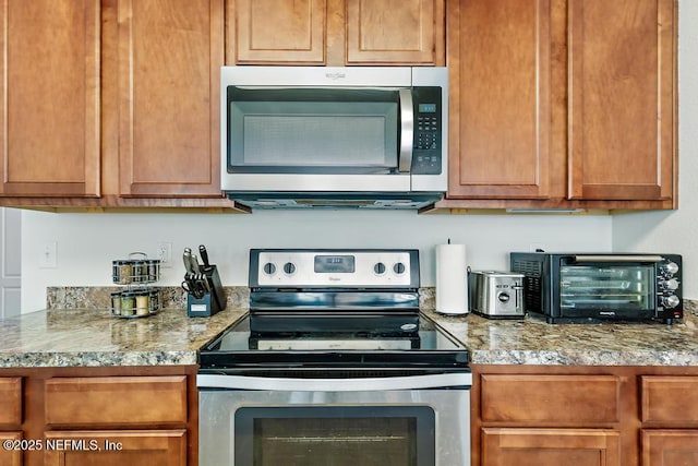 kitchen featuring a toaster, brown cabinets, and stainless steel appliances