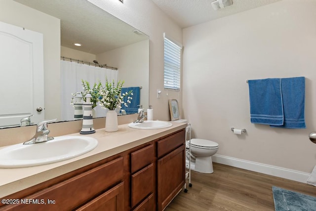 full bathroom with visible vents, toilet, wood finished floors, and a sink