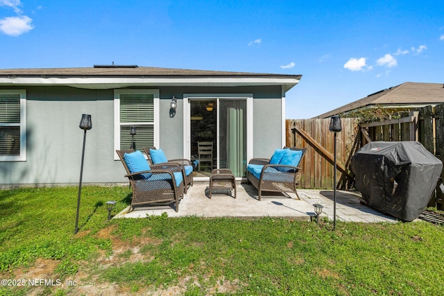 rear view of property featuring stucco siding, a lawn, a patio, and fence