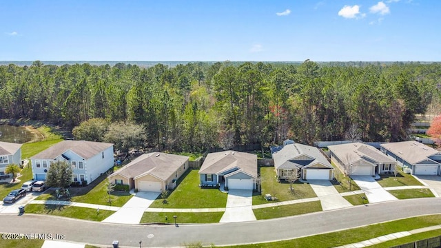 birds eye view of property featuring a wooded view and a residential view