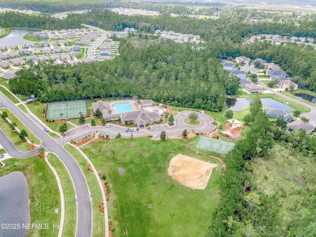 bird's eye view with a water view and a wooded view