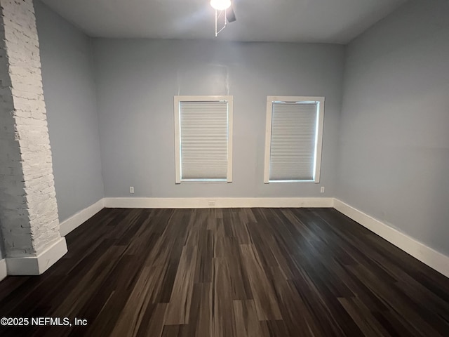 spare room with dark wood finished floors and baseboards