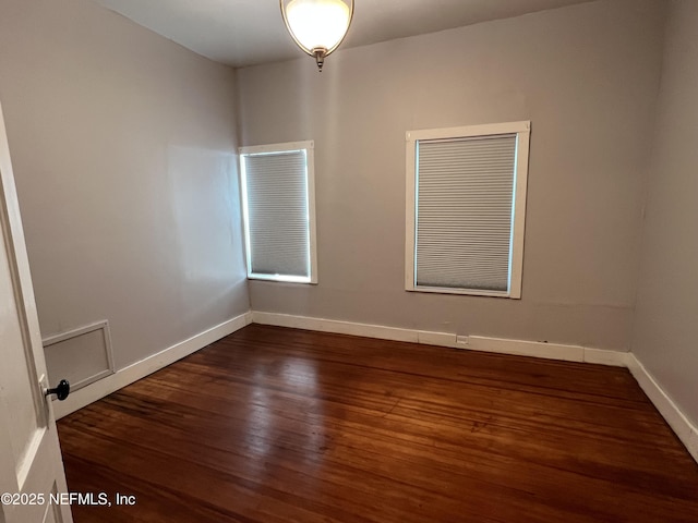 unfurnished room featuring baseboards and wood finished floors