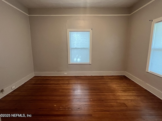 spare room featuring wood finished floors, baseboards, and a healthy amount of sunlight