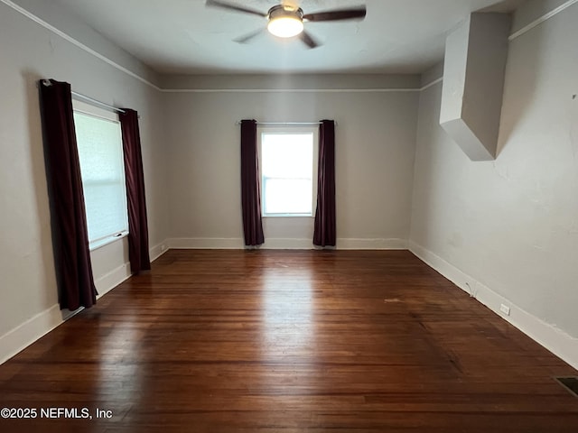 spare room with wood finished floors, baseboards, and ceiling fan