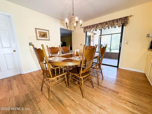 dining room featuring light wood-style floors, baseboards, and a chandelier