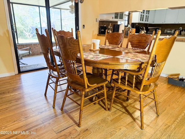 dining space featuring baseboards and light wood-style floors