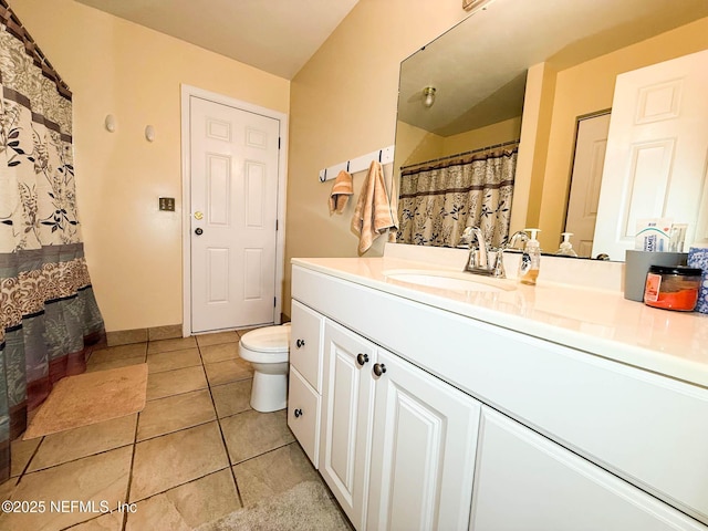 full bath featuring toilet, vanity, and tile patterned flooring