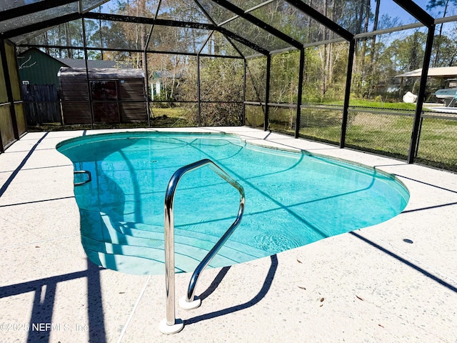 pool featuring an outbuilding, a patio area, a lanai, and a storage shed