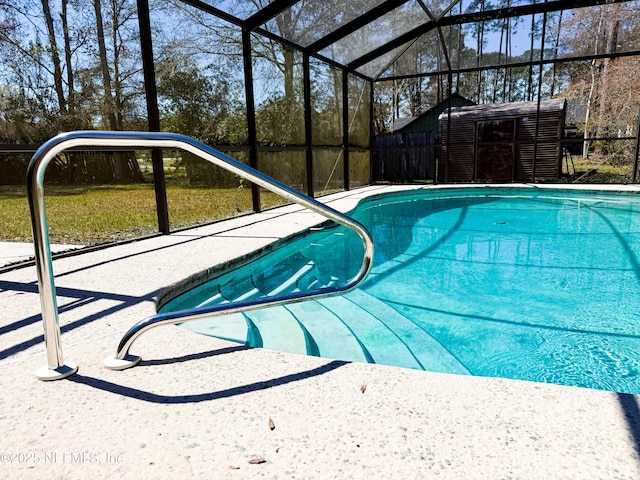 outdoor pool featuring an outbuilding, glass enclosure, and a storage shed