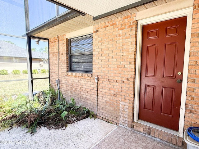 doorway to property featuring brick siding