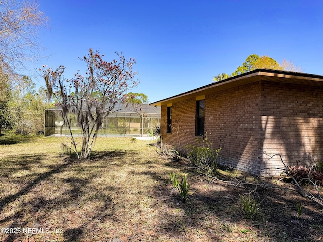 view of side of property featuring a lawn and brick siding