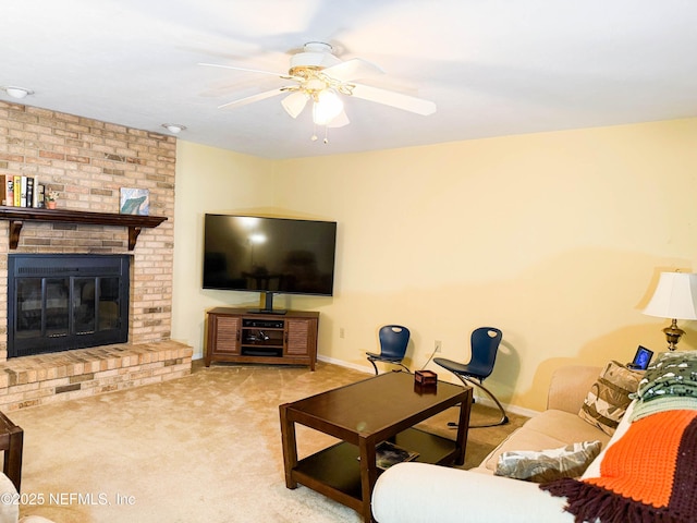 living room featuring a brick fireplace, a ceiling fan, baseboards, and carpet floors