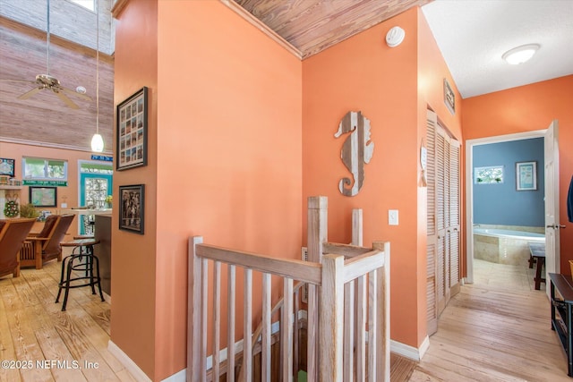 hallway featuring hardwood / wood-style floors, an upstairs landing, visible vents, and baseboards