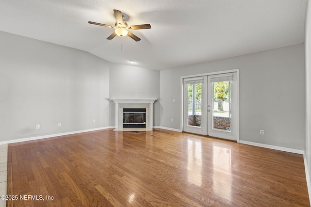 109 N Lake Cunningham Ave, Saint Johns, FL 32259 - unfurnished living room featuring a fireplace with flush hearth, baseboards, wood finished floors, and a ceiling fan