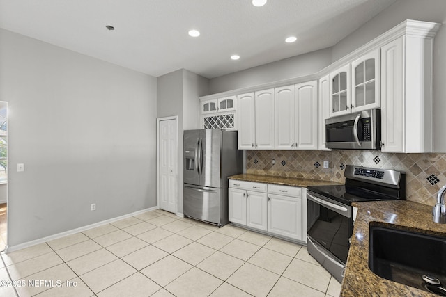 109 N Lake Cunningham Ave, Saint Johns, FL 32259 - kitchen with white cabinetry, backsplash, a sink, appliances with stainless steel finishes, and glass insert cabinets