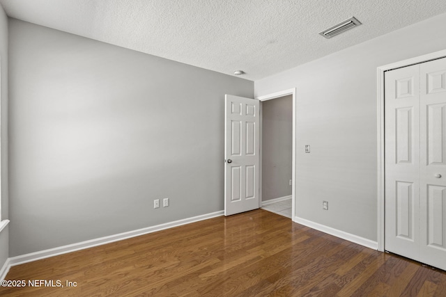 109 N Lake Cunningham Ave, Saint Johns, FL 32259 - unfurnished bedroom featuring a closet, a textured ceiling, visible vents, baseboards, and wood finished floors