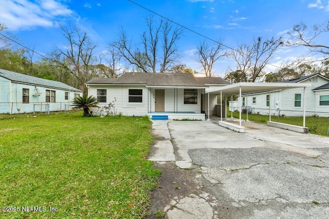 view of front of property with an attached carport, fence, a porch, a front yard, and driveway