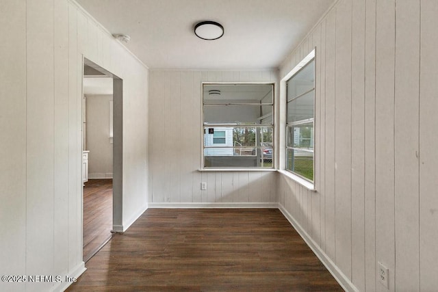 hallway featuring baseboards and dark wood-type flooring