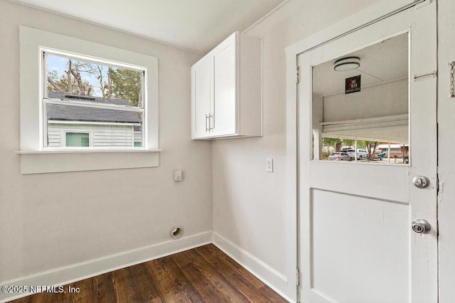 laundry room featuring dark wood-style floors, cabinet space, and baseboards