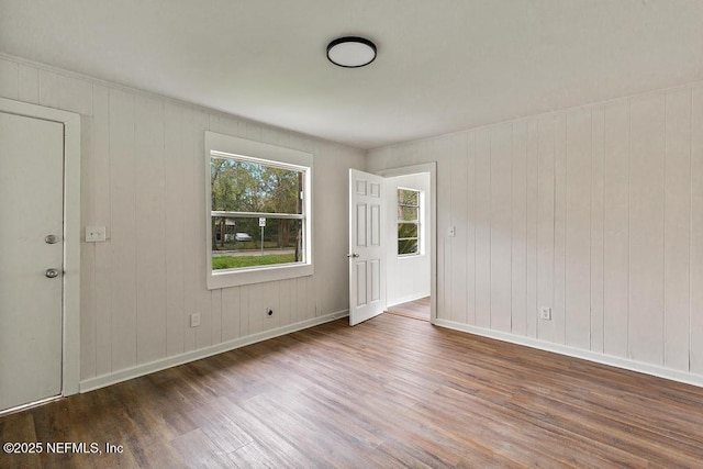 spare room featuring baseboards and wood finished floors