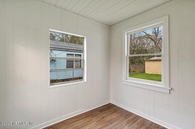 empty room with dark wood finished floors and baseboards