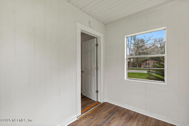 unfurnished room featuring dark wood-type flooring, baseboards, and a wealth of natural light