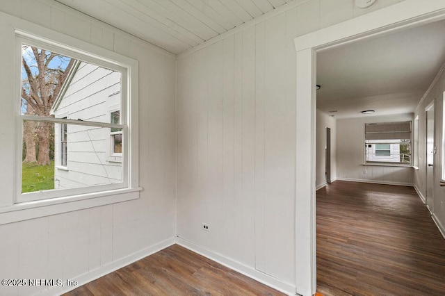 empty room with baseboards and dark wood-style flooring