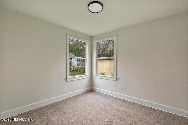 spare room with carpet and baseboards