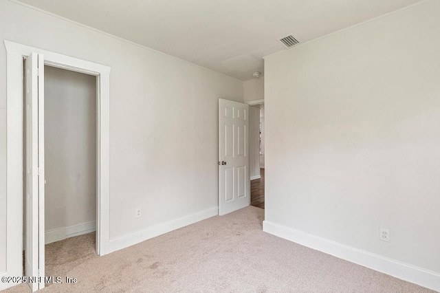 unfurnished bedroom with baseboards, visible vents, and carpet floors