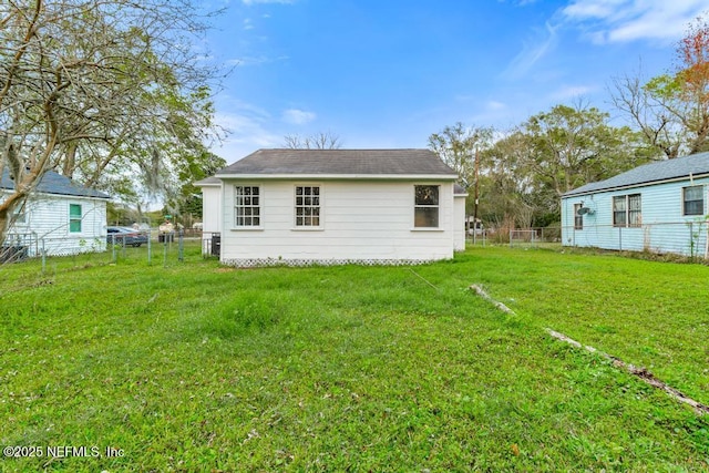 back of house featuring a yard and fence