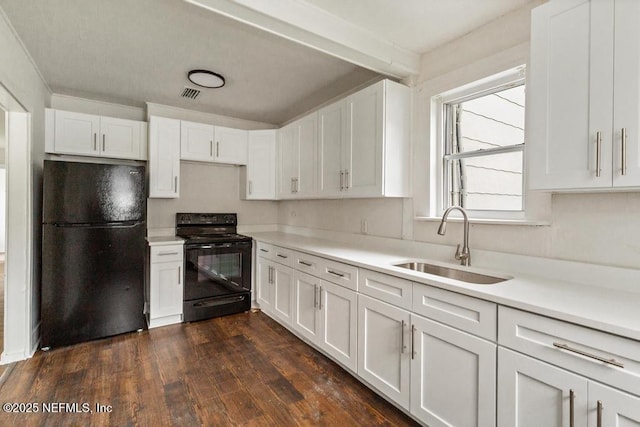 kitchen with visible vents, white cabinetry, black appliances, and a sink