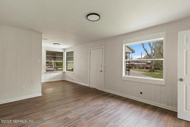 empty room with plenty of natural light, baseboards, and wood finished floors