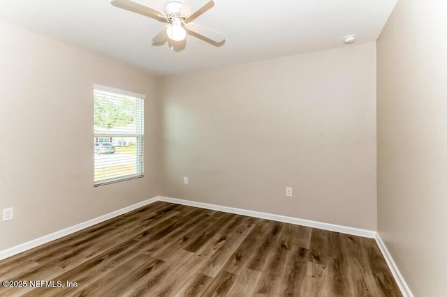 spare room featuring dark wood finished floors, baseboards, and ceiling fan