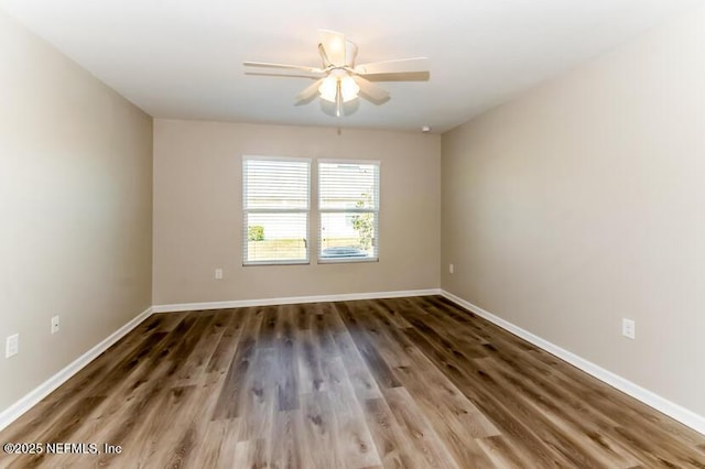 empty room featuring ceiling fan, baseboards, and wood finished floors