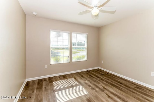 spare room featuring wood finished floors, baseboards, and ceiling fan