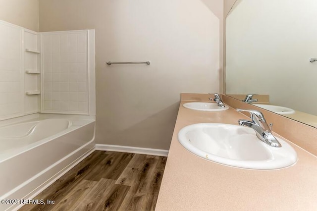 full bath with wood finished floors, baseboards, and a sink