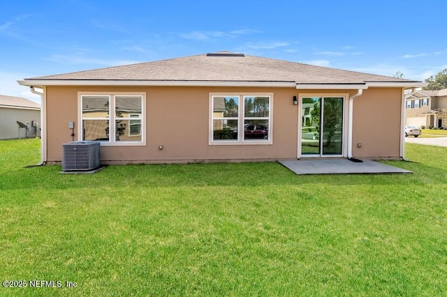 rear view of property featuring a lawn, cooling unit, and stucco siding