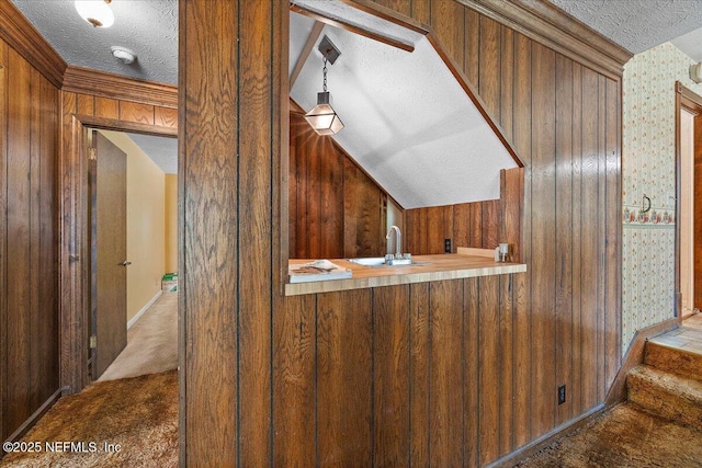 bathroom featuring a sink, wood walls, and a textured ceiling