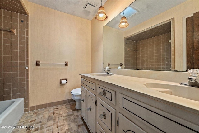 full bath with double vanity, toilet, baseboards, and a sink