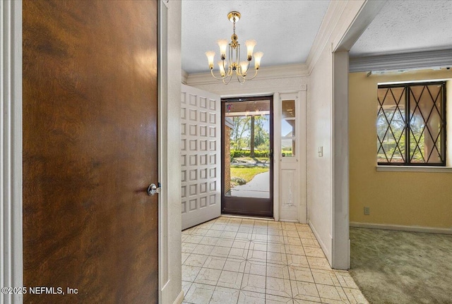 entryway with a textured ceiling, ornamental molding, plenty of natural light, and a chandelier