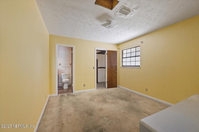 unfurnished bedroom featuring visible vents, baseboards, carpet flooring, ensuite bathroom, and a textured ceiling