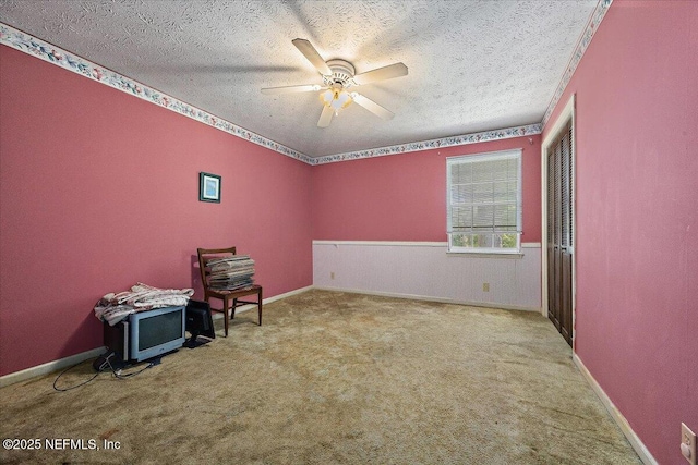 interior space with ceiling fan, baseboards, and a textured ceiling