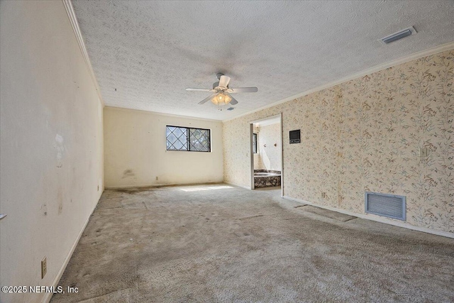 unfurnished room with visible vents, a textured ceiling, crown molding, and carpet